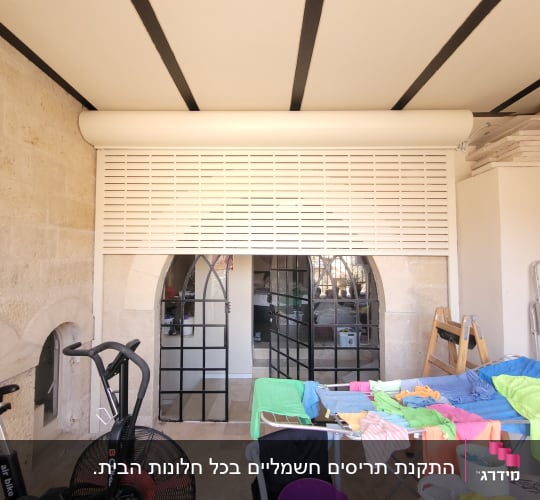 תריס אלומיניום לבן סגור על קיר אבן